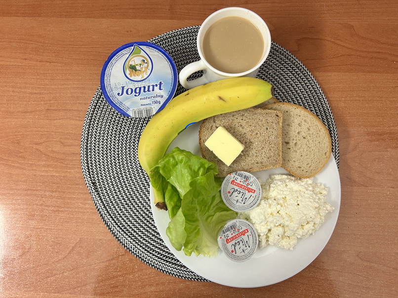 Na zdjęciu: Jogurt naturalny, Kawa zbożowa z mlekiem, Chleb mieszany pszenno-żytni, Chleb Graham, Masło extra 82%, Twarożek, Miód, Banan, Sałata zielona